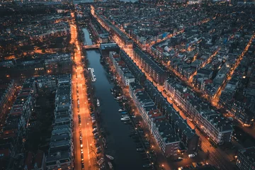 Gardinen Amsterdam, Netherlands. Aerial top view of old city from above at night with canals and houses. © DedMityay