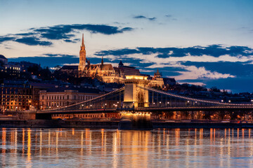 Fototapeta na wymiar Twilight in Budapest, the Chain Bridge over the Danube, the reflection of night lights on the water