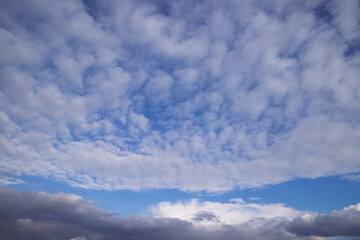 Naklejka na ściany i meble Blue spring sky covered with various clouds.