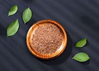 Organic flax seeds in the wooden bowl - Linum usitatissimum
