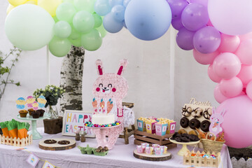 candy table decorated with easter bunny and carrots.