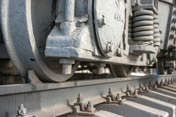 Fototapeta na wymiar Carriage bogie, perspective view. The main element of the carriage running gear, close-up. A wagon bogie on a railway track. Fragment of the railroad track.