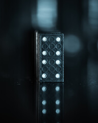 Dramatic creative image of dominos with a dark and blurry bokeh background