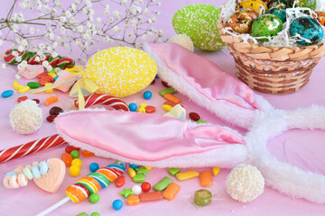 Fototapeta na wymiar Easter composition with sweets, rabbit ears and tulips. Happy Easter greeting card.