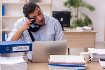 Young male employee sweating at workplace