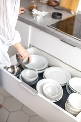 Obraz na płótnie Canvas Comfortable white gray kitchen interior open box full of various crockery porcelain or glass plates