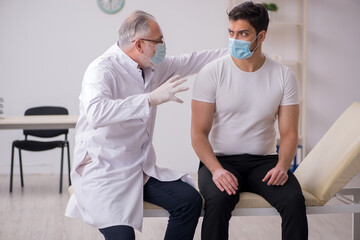 Obraz premium Young male patient visiting old male doctor in vaccination conce
