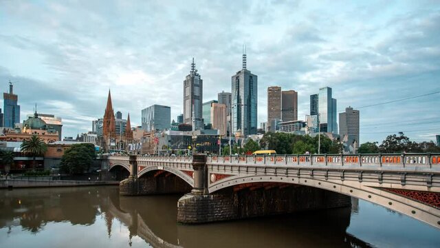 Time lapse from day to night of the skyscrapers in Melbourne city centre and the vehicles passing by on the Princes Bridge over the Yarra River
