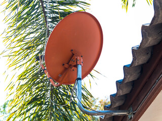 The orange satellite dish on the roof is used to receive TV signals. On the roof of the house