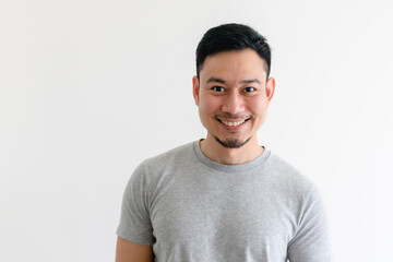Happy and confident Asian man in grey t-shirt on isolated white background.