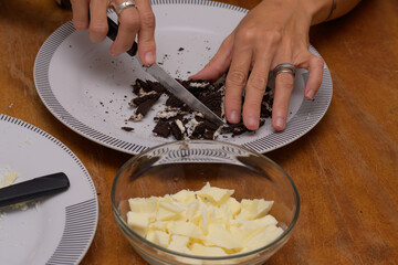 Hands breaking cookies to make easter eggs and pots with white chocolate