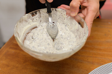 Melted white chocolate with pieces of cookies to prepare easter eggs