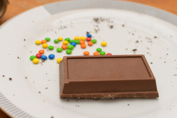 Chocolate bar and colored sprinkles to prepare Easter eggs