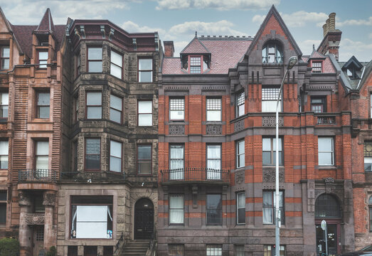 Street view of an old, red brick apartment building in Philadelphia