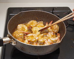 殻付きのエビを素揚げしている