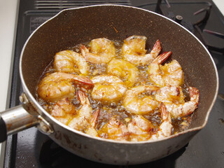 殻付きのエビを素揚げしている