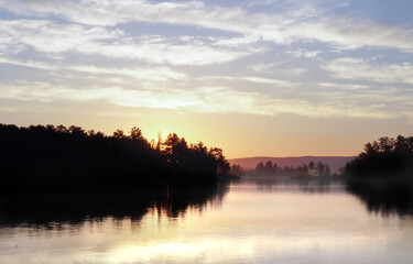 Valley river during the morning sunrise with fog.
