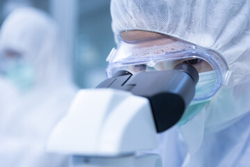Close up Asian man scientist is wearing Personal Protective Equipment (PPE) Looking sample blood...