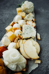 cheese plate with different types of cheeses: mozzarella, Georgian, cottage cheese, smoked, parmesan, spicy, hard varieties. fresh tomatoes, cup of honey. cheese menu vertically, selective focus