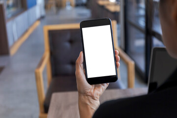 Close up hands of woman using mobile phone, cell phone in coffee shop. Hands of women holding blank empty screen smart phone in cafe. Women relax with mobile phone sit in restaurant