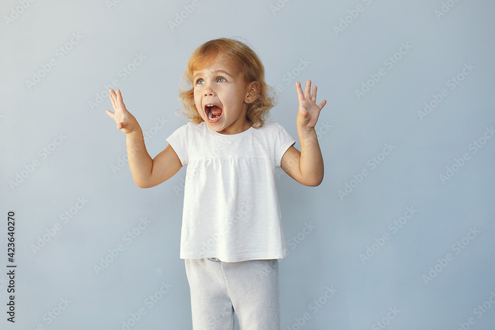 Sticker Cute little girl sitting in a studio on a blue background