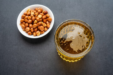 A glass of beer and peanuts
