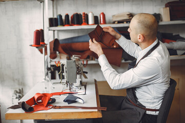 Man in a studio creates leather ware