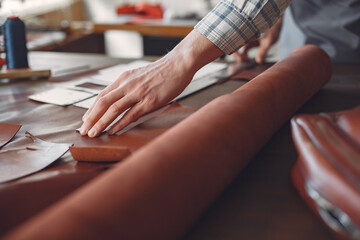 Man in a studio creates leather ware
