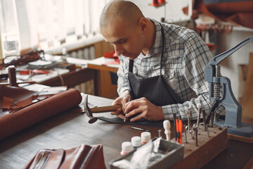 Man in a studio creates leather ware
