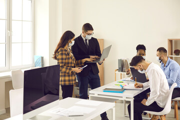 Male boss chief checking employee financial statistics, diverse business team working together in face mask Interracial businesspeople colleague wearing face mask cooperating in new normal office