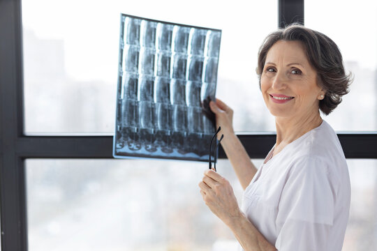 Doctor woman examining spine x-ray film of patient at hospital