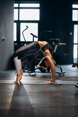 Fototapeta na wymiar Slim athletic woman doing exercise bridge at gym