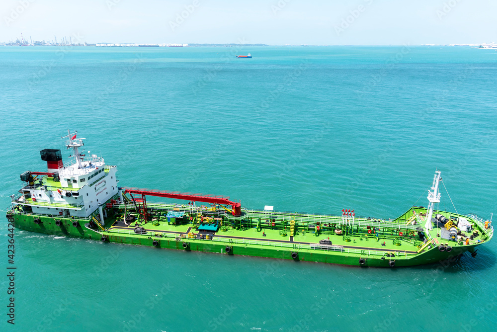 Wall mural port of singapore, bunker barge on her way to supply fuel oil to large container vessels.