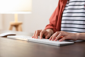 Fototapeta premium Hand holding a computer mouse and keyboard on the office desk.