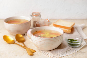 Bowls with tasty garlic soup on light background