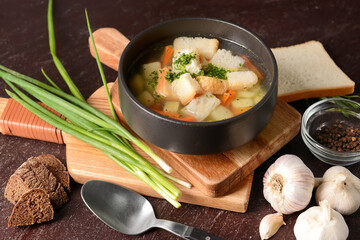 Bowl with tasty garlic soup on dark background