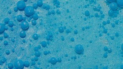 Bright neon blue bubbles oil and ink, beautiful fluorescent paint. Sparkling color multicolor moving close-up. Acrylic painting. Themes or wallpaper background. Abstract transformation gravitation