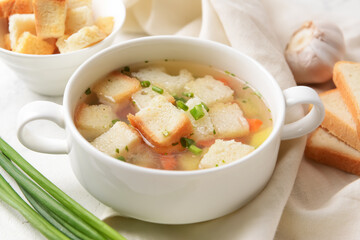 Bowl with tasty garlic soup on light background, closeup
