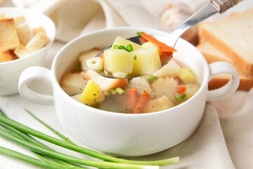 Bowl with tasty garlic soup on light background, closeup