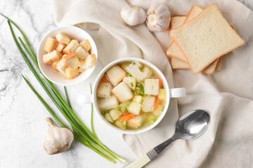 Bowl with tasty garlic soup on light background