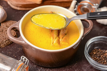 Bowl with tasty garlic cream soup on dark background