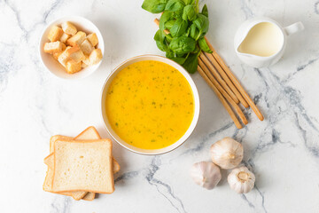 Bowl with tasty garlic cream soup on light background