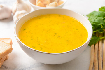 Bowl with tasty garlic cream soup on light background