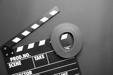Cinema clapperboard with reel on dark background