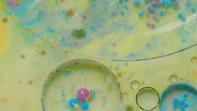Colorful green yellow bubbles wallpaper themes background. Multicolor space universe concept. Fantastic hypnotic surface. Abstract pattern chemical reaction texture liquid paint motion bubble in water