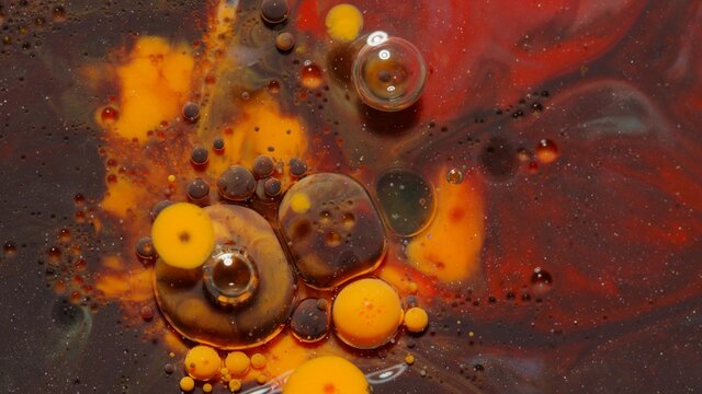 Bright ink bubbles mixed with liquid substance of oil, milk, soap. Floating acrylic paint on colorful surface. Abstract multicolor macro hypnotic transformation themes or wallpaper painting background