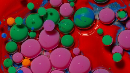 Top view fantastic structure of colorful oil paint and ink bubbles. Chaotic motion. Abstract colorful paint. Movement in liquid. Water surface multicolored texture background. Macro. Pattern, design