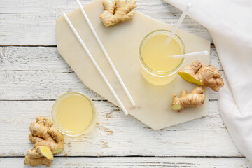 Composition with healthy ginger juice on white wooden background