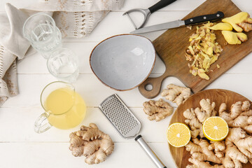 Composition with healthy ginger juice on white wooden background