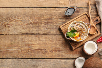Cooking pot with Thai noodle soup on wooden background